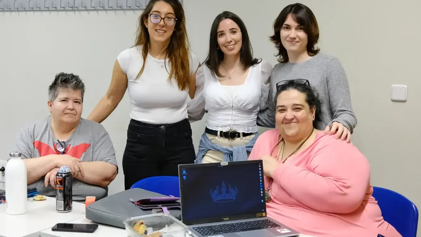 5 personas compartiendo un rato delante de un portátil corriendo GNU/Linux.