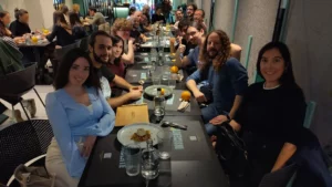 Una muntonada de gent de l'associació GNU/Linux València es troba sentada en un restaurant, després d'un dinar de comunitat.