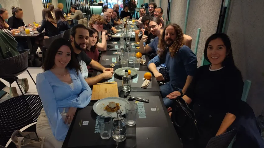 Una muntonada de gent de l'associació GNU/Linux València es troba sentada en un restaurant, després d'un dinar de comunitat.